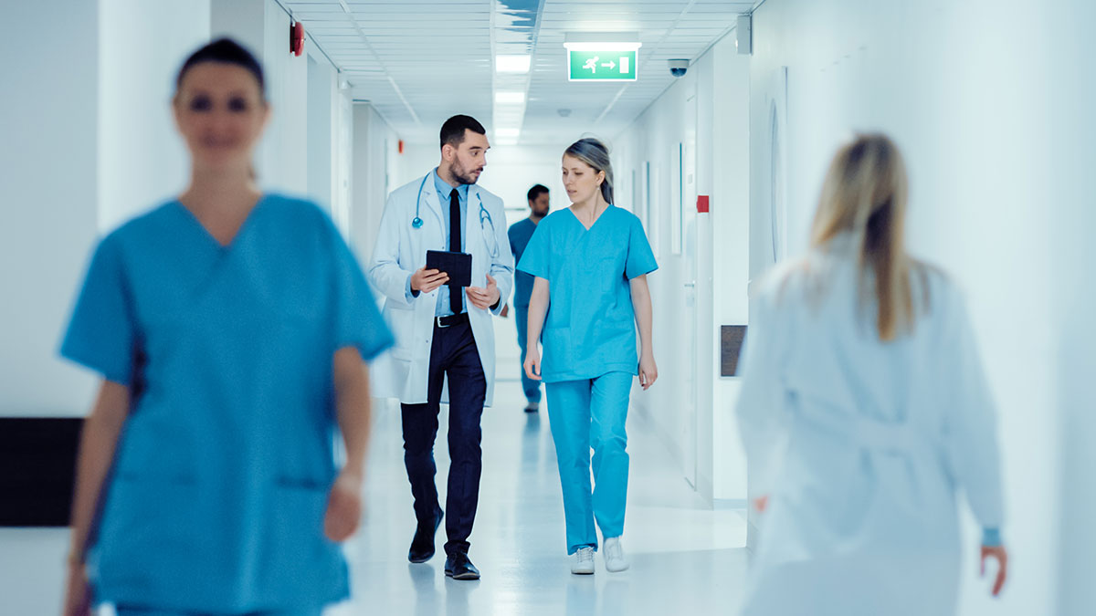 hospital hallway with doctors and nurses walking